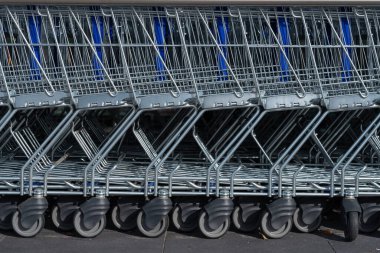 Süpermarketin girişindeki otoparkta alışveriş arabaları.