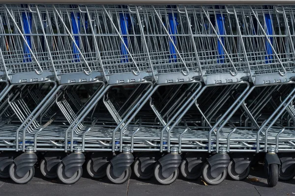 Shopping carts on car park near entrance of supermarket