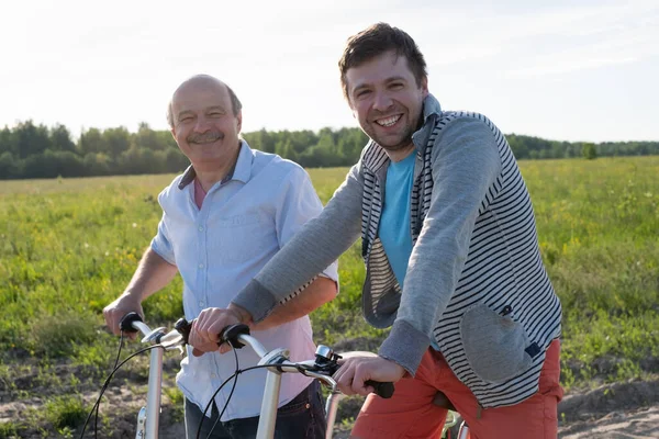 Батько і син катаються на велосипедах на відкритому повітрі . — стокове фото