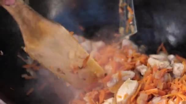 Homem está mexendo prato de refeição em panela grande com concha de madeira . — Vídeo de Stock