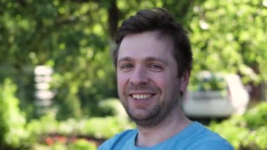 Tatmin olmuş, gülümseyen genç erkek.