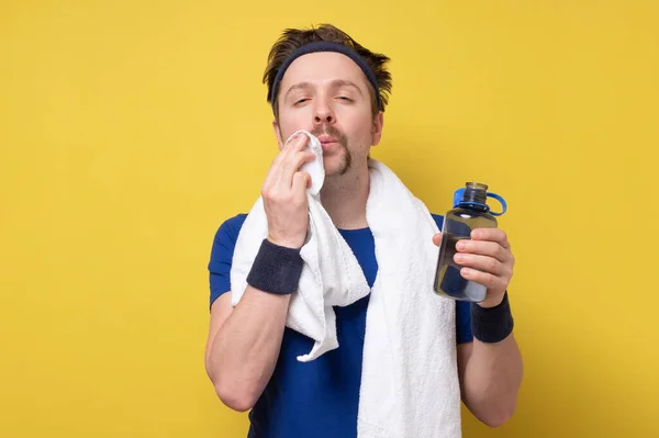 Hombre atlético joven con botella de agua después de su ejercicio en el gimnasio — Foto de Stock