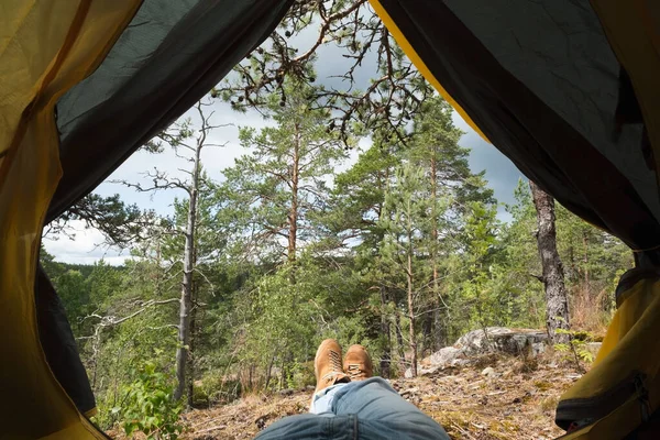 하이킹을 하고 휴식을 취하는 동안 텐트 밖으로 나오는 남성 부츠. — 스톡 사진