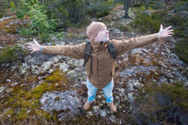 Genç beyaz bir adam ormanda yürüyüş yapıyor dinleniyor.
