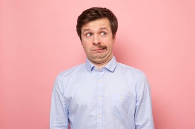 Pembe duvarda tıraş olduktan sonra yarım bıyıklı beyaz bir adam.