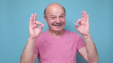 Orta yaşlı adam olumlu gülümsüyor. Tamam işareti onaylıyor..