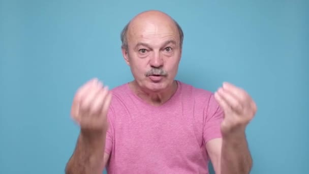 Älterer Mann sieht wütend aus und zeigt italienische Geste — Stockvideo