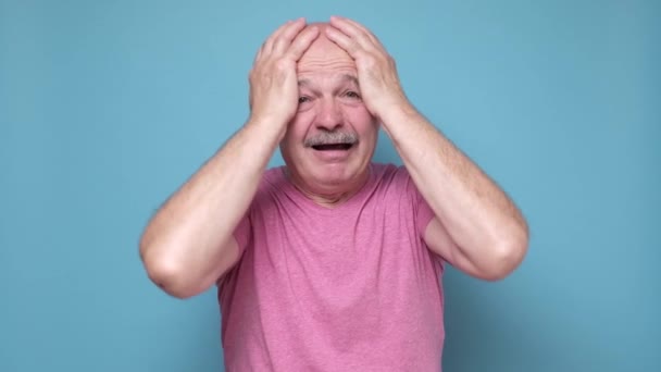 Hombre hispano mayor en shock mirando a la cámara con emoción facial desesperada. — Vídeos de Stock