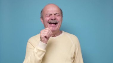 Yaşlı kel adam sıkıldı ve esniyor..