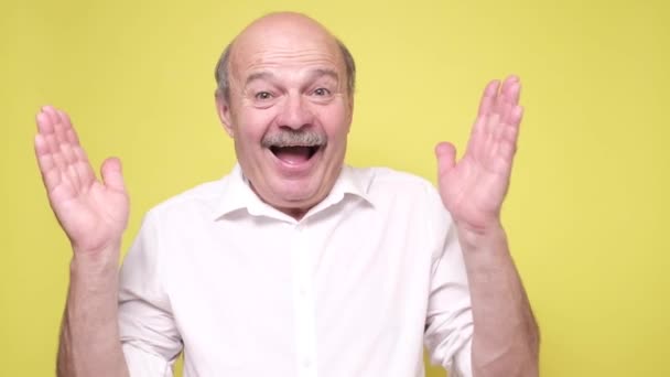 Sorprendido hombre hispano mayor siendo excitado con las noticias. — Vídeos de Stock