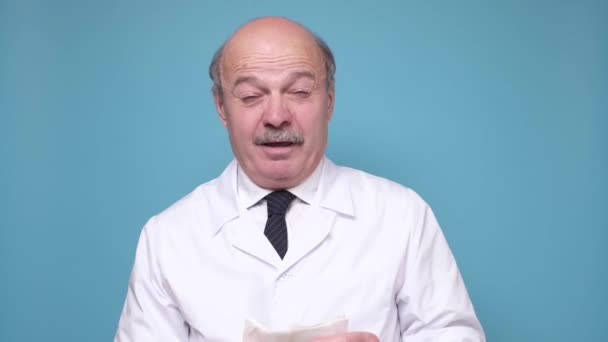 Starszy biały mężczyzna lekarz kichanie za pomocą chusteczki — Wideo stockowe
