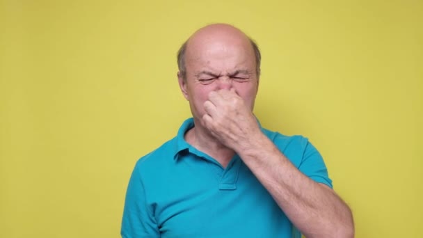 年长的惊慌失措的男人因为难闻的气味而捂住鼻子 — 图库视频影像