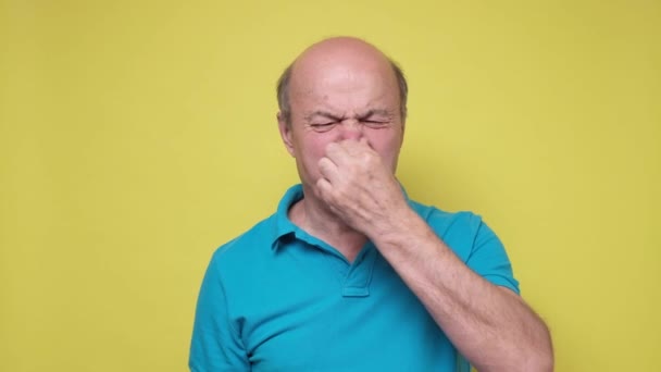 Senior hispanic man holding his nose against because of a bad smell — Stock Video