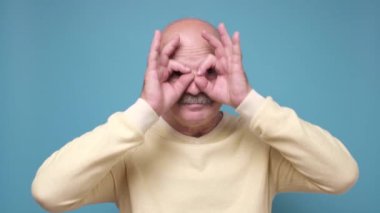 Gözlük gibi parmakları olan kıdemli bir adam mı yoksa süper kahraman gibi maske takan biri mi?.