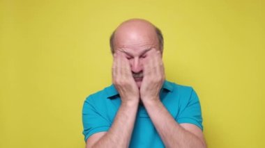 Kafkasyalı kıdemli adam elleriyle gözlerini kapatıyor.