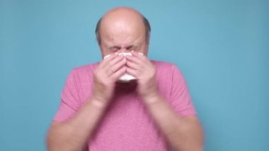 Hastalıklı adam hasta olduğu için burnunu kağıt mendile sümkürmüş.