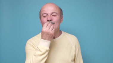 Kıdemli adam lezzetli jestler yapıyor.