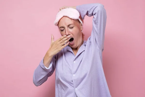 Bostezar mujer caucásica cansado con máscara para dormir —  Fotos de Stock