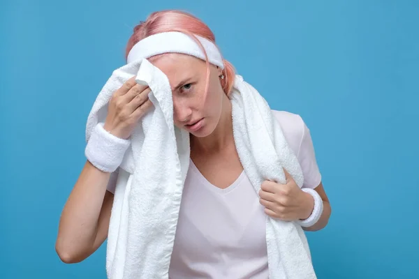 Недовольная уставшая женщина вытирает швабру с лица после тренировки в спортзале — стоковое фото