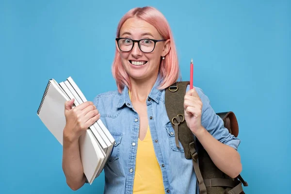 Mulher jovem caucasiana com livros apontando para cima ter ideia . — Fotografia de Stock