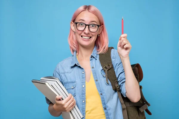 Mulher jovem caucasiana com livros apontando para cima ter ideia . — Fotografia de Stock