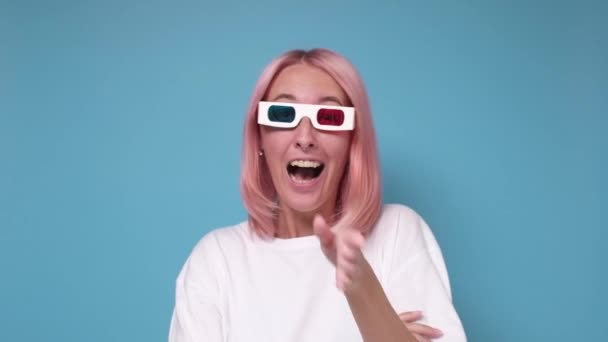 Jonge vrouw in 3D bril kijken horror film of komedie op blauwe muur. — Stockvideo