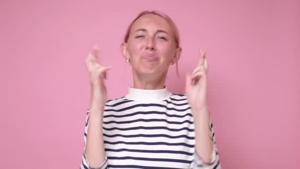 Jong aantrekkelijk vrouw houdt haar vingers gekruist en ogen dicht — Stockvideo