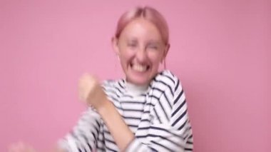 Güzel beyaz kız pembe arka planda dans ediyor..