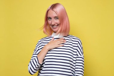 Memnun bayan öğrenci bir iltifat duymaktan memnunmuş gibi elini göğsüne koyuyor.