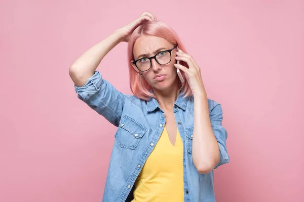 Mulher de óculos falando ao telefone sendo confundido. — Fotografia de Stock