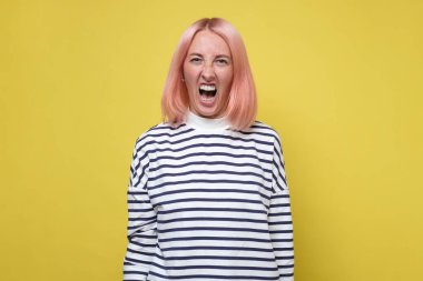 Kızgın genç kadın, ağzı açık bağırıyor.