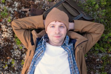 İnsan ormanın ortasında dinlenmek için çimenlere uzanır.