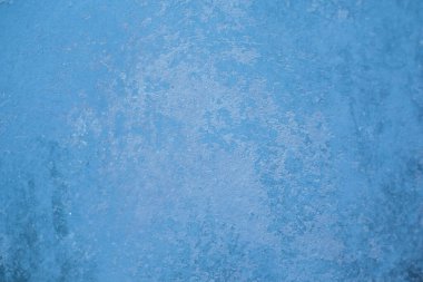 Mavi duvarın arkasında çizikler ve lekeler var.