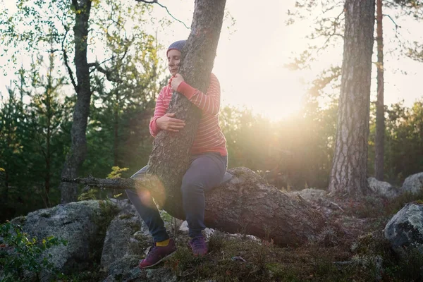 Kavkazská žena těší letní večer venku objímání stromu. — Stock fotografie