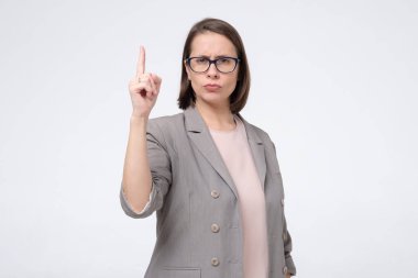 Olgun bir kadın uyarı olarak parmağını kaldırıyor..