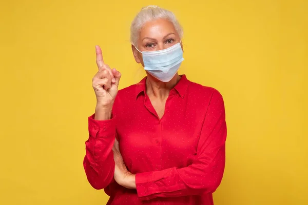 ウイルス指紋指アップから保護のための保護医療マスクを身に着けているシニア女性 — ストック写真