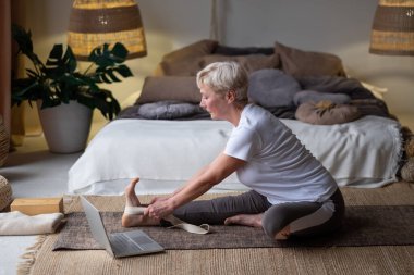Üst düzey kadın yoga konsepti çalışıyor, Janu Sirsasana egzersizi yapıyor, Diz çöküp poz veriyor.