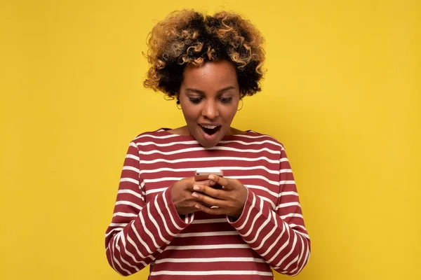 Молода африканська дівчина використовує мобільний телефон, вводячи смс-повідомлення — стокове фото