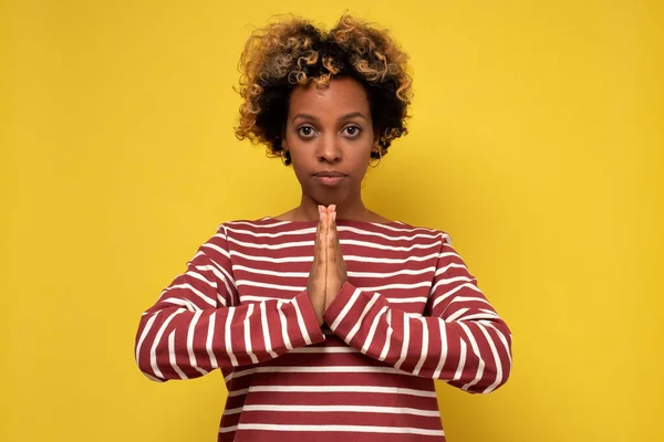 Woman practising yoga calming down release stress, press palms together namaste praying gesture.