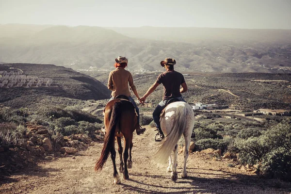 love and friendship concept outdoor for people ride horses in the countryside. amazing landscape and a world to discover traveling together. caucasian man and woman