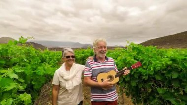 güzel güzel yetişkin çift beyaz saç yürüyüş alanları bir ukulele gitar çalmak şarap. güzel ile birlikte sonsuza kadar mutluluk ve delilik kavramı. emekli için farklı yaşam tarzı