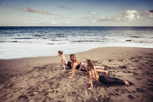 Tres Señoritas Caucásicas Haciendo Pilates Orilla Cerca Las Olas Océano —  Fotos de Stock