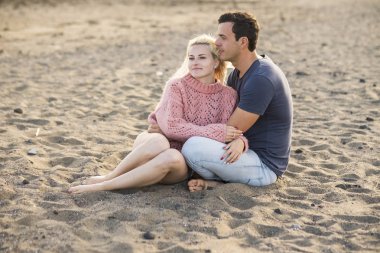 güzel çift ilişkide tatil sahilde oturuyor. tatlılık ile beyaz genç adam ve kadın. sarı ve beyaz cilt aşk ve yaş tadını çıkarın. Yaz konsepti