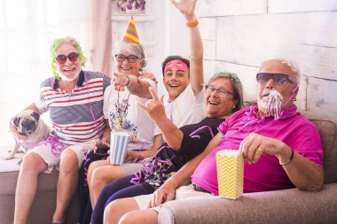 Grup yaşlı iki adam, iki kadın, bir çocuk ve bir küçük boksör birlikte vakit geçirmek. Oynama ve kılık ve renkli maskeleri evde ile gülüyor