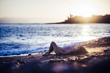 güzel beyaz genç kadın güzel güneşin tadını çıkar ve sahilde tatil günün sonunda günbatımında sırasında relax. Okyanus Doğa açık hava etkinliği için sevimli bayan Okyanusu yakın yaşam tarzı zevk