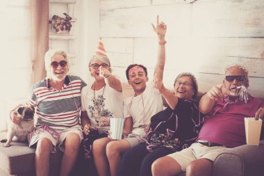 Grup yaşlı iki adam, iki kadın, bir çocuk ve bir küçük boksör birlikte vakit geçirmek. Oynama ve kılık ve renkli maskeleri evde ile gülüyor