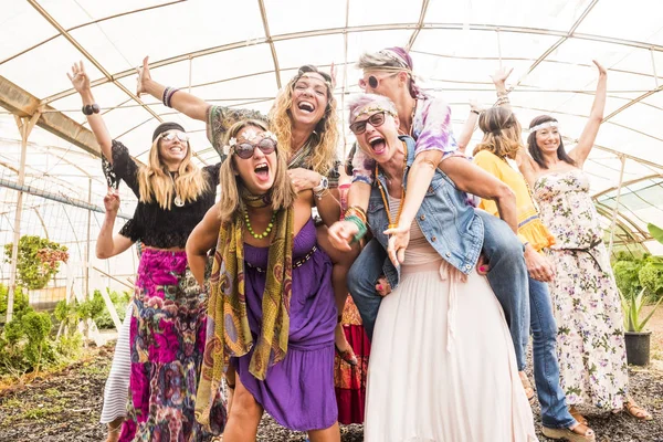 group with many girls caucasian beautiful models have fun together celebrating with colorful dresses and friendship all together. playing carrying on the back and a lot of smiles and laughs