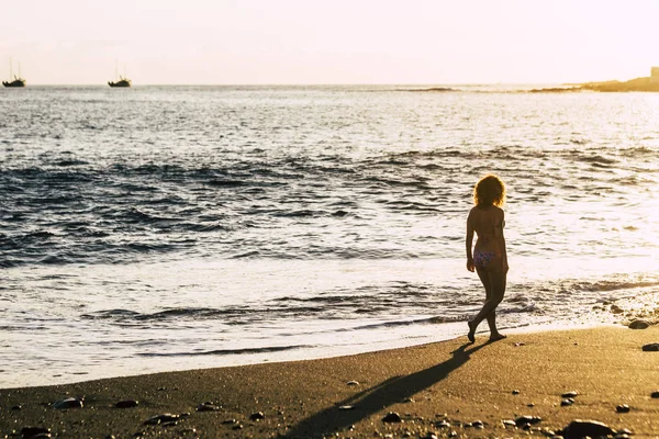 美丽瘦的女性白种人走在岸边附近的海浪 享受假期和自由的生活方式接触自然 地平线和日落时间 脚上的沙子和快乐的夏天 — 图库照片