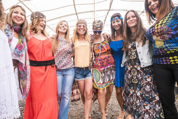 friendship with group o many females walking and celebrating together in a colored hippy and alternative rock festival. everybody smiles and have fun together. summer event go crazy concept