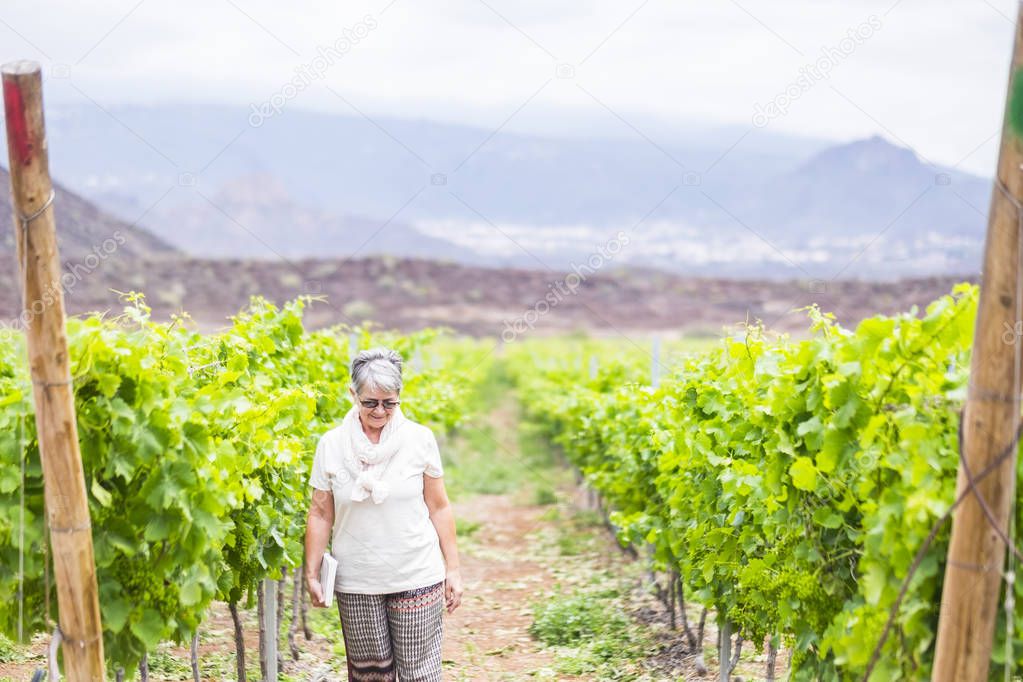 senior adult woman walking in vineyard 